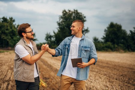 Photo for Two Caucasian men greeting one another inn the field before work. - Royalty Free Image