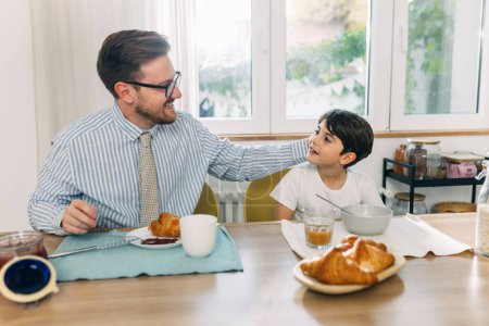 Photo for Father and son talking and bonding over breakfast. - Royalty Free Image