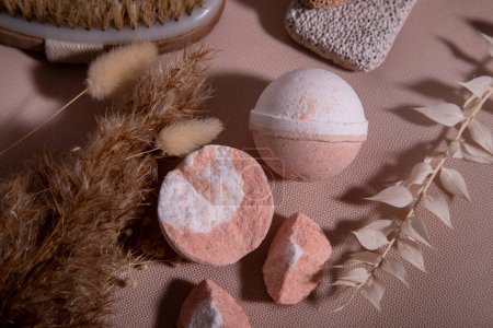 Photo for Facilities for spa treatments. Masage brush, leg pumice, bathroom bombs on a peach background. Top view - Royalty Free Image