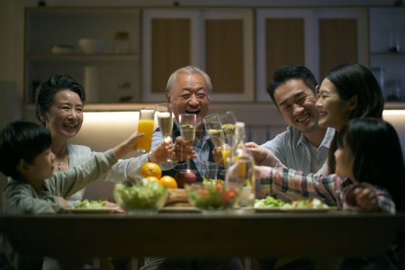 Photo for Three generation asian family gathering at home celebrating holiday having a toast - Royalty Free Image