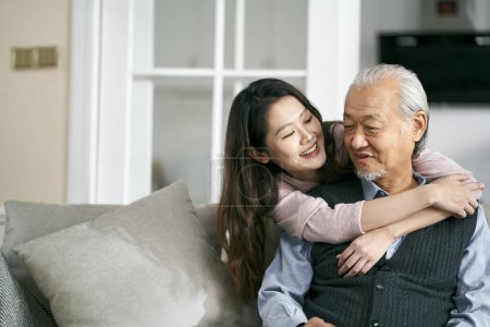 Photo for Asian senior father and adult daughter sitting on couch in living room at home  enjoying a pleasant conversation - Royalty Free Image