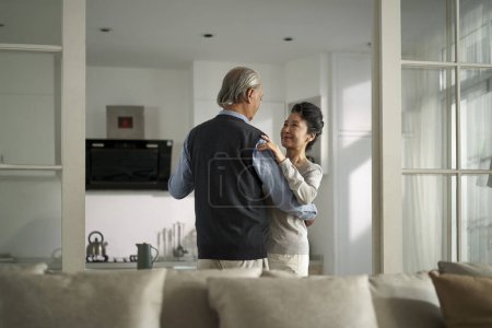 Photo for Loving romantic senior asian couple dancing in living room at home - Royalty Free Image