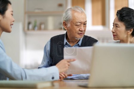 Photo for Senior asian couple appears confused by and suspicious at a sales person selling financial product - Royalty Free Image