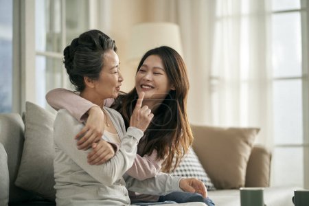 Téléchargez les photos : Happy senior asian mother and adult daughter having a good time at home - en image libre de droit