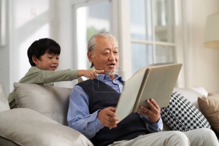 Téléchargez les photos : Senior asian grandfather having a good time with grandson at home - en image libre de droit