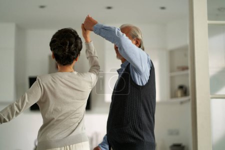 Téléchargez les photos : Loving romantic senior asian couple dancing in living room at home - en image libre de droit