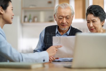 Foto de Senior asian couple appears confused by and suspicious at a sales person selling financial product - Imagen libre de derechos