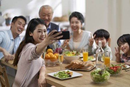 Téléchargez les photos : Three generational asian family taking a selfie while having meal together - en image libre de droit