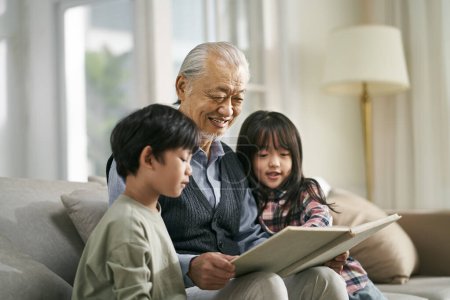 Téléchargez les photos : Asian grandfather having a good time telling story to cute grandson and granddaughter - en image libre de droit