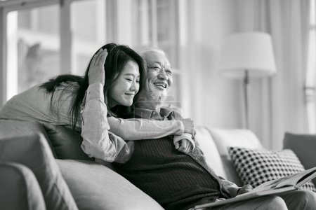Photo for Asian adult daughter and senior father enjoying conversation and good time at home, black and white - Royalty Free Image