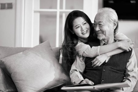 Téléchargez les photos : Asiatique père aîné et adulte fille assis sur canapé dans salon à la maison profiter d'une agréable conversation, noir et blanc - en image libre de droit