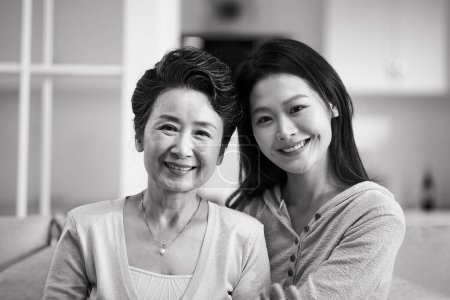 Téléchargez les photos : Portrait de mère aînée asiatique et fille adulte regardant camra souriant, noir et blanc - en image libre de droit