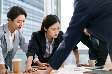 Foto de Equipo de ejecutivos corporativos asiáticos se reúnen en la oficina analizando datos sobre planes de negocios - Imagen libre de derechos