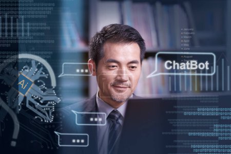 Foto de Asiático hombre de negocios sentado en escritorio charlando con un AI ChatBot utilizando ordenador portátil - Imagen libre de derechos
