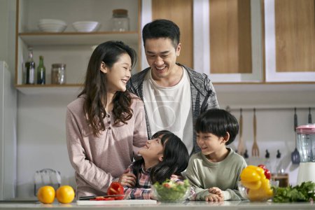 Photo for Happy asian family with two children enjoying a good time together in kitchen at home - Royalty Free Image