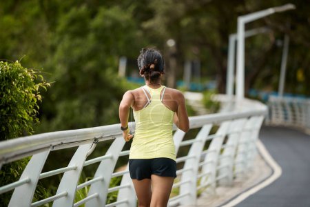 Foto de Vista trasera de joven asiático mujer corriendo jogging ejerciendo al aire libre en ciudad parque - Imagen libre de derechos