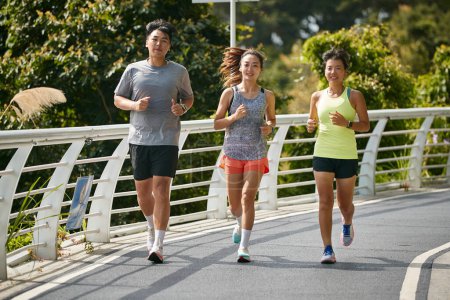 Foto de Tres jóvenes asiático mujeres joggers ejercicio al aire libre juntos en ciudad parque - Imagen libre de derechos