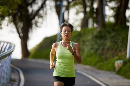 Photo for Young asian woman female jogger exercising outdoors in city park - Royalty Free Image