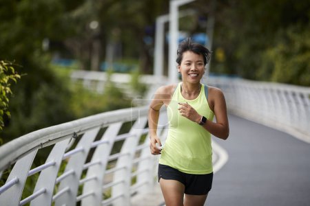 Photo for Young asian woman running jogging outdoors in park - Royalty Free Image