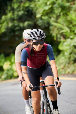 Foto de Joven asiático mujer ciclistas equitación bicicleta formación en rural camino - Imagen libre de derechos