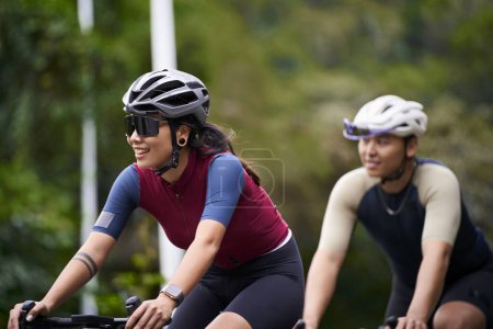 Photo for Young asian couple cyclists riding bike on rural road - Royalty Free Image