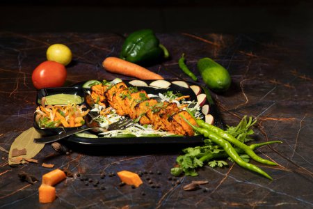 Téléchargez les photos : Paneer tikka est un plat indien à base de morceaux de paneer avec sauce et légumes sur la table - en image libre de droit