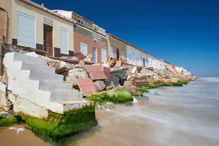 Téléchargez les photos : Maisons endommagées sur la côte de la mer en raison du réchauffement climatique et des inondations - en image libre de droit