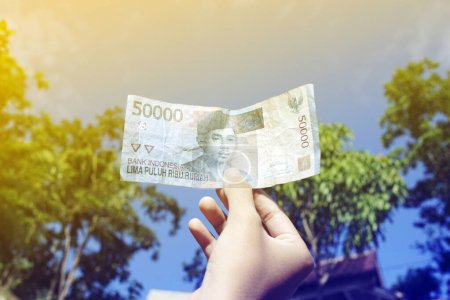 Photo for Fifty thousand rupiahs. money from Indonesia is held by women - Royalty Free Image