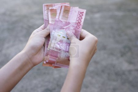 people show Indonesian money as a legal payment instrument