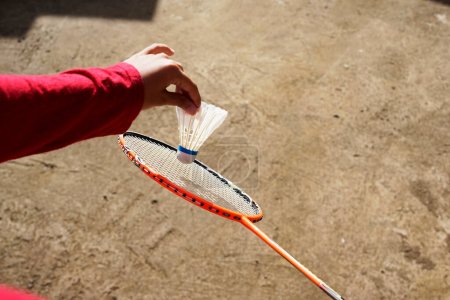 Téléchargez les photos : Main fermée tenant la navette de badminton se préparant à servir - en image libre de droit
