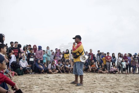 Téléchargez les photos : Sukabumi, Indonésie (30 12 2019) : le guide donne aux visiteurs des indications pour se préparer à relâcher les nouveau-nés en pleine mer à la plage d'Ujung Genteng - en image libre de droit