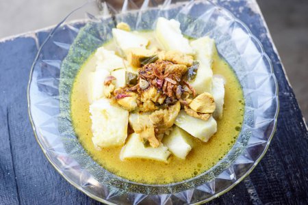 Indonesian Traditional Cuisine: Lontong kari ayam, Rice or Ketupat Served with Chicken Curry Soup Made from Chicken Broth and Light Coconut Milk, Various Indonesian Spices and Herbs