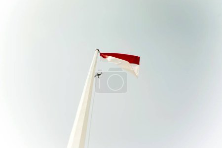 Téléchargez les photos : Drone coincé sur le mât du drapeau indonésien - en image libre de droit