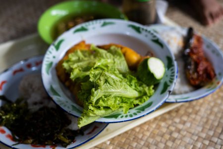 Foto de Lalapan o cesta de verduras crudas frescas. comido con salsa de chile como alimento complementario. auténtica comida indonesia - Imagen libre de derechos