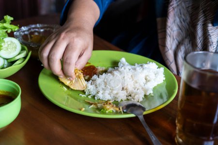 Téléchargez les photos : Les gens mangent du riz complet. les gens mangent des aliments sundaniens - en image libre de droit