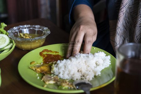 Foto de La gente come arroz completo. la gente come comida sundanesa - Imagen libre de derechos