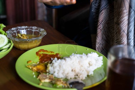Téléchargez les photos : Les gens mangent du riz complet. les gens mangent des aliments sundaniens - en image libre de droit