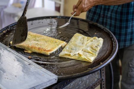 Making process of Martabak Telor. Savoury pan-fried pastry stuffed with egg, meat and spices