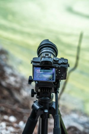 a mirrorless camera on a tripod is capturing an image