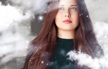 Foto de Belleza de invierno, Navidad y felices fiestas, hermosa mujer con peinado largo y maquillaje natural detrás de la ventana congelada, nevando diseño de nieve como Navidad, Año Nuevo y estilo de vida de vacaciones retrato - Imagen libre de derechos