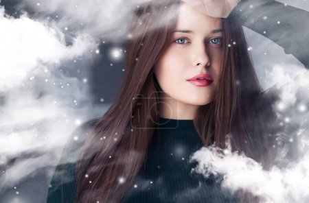 Foto de Belleza de invierno, Navidad y felices fiestas, hermosa mujer con peinado largo y maquillaje natural detrás de la ventana congelada, nevando diseño de nieve como Navidad, Año Nuevo y estilo de vida de vacaciones retrato - Imagen libre de derechos