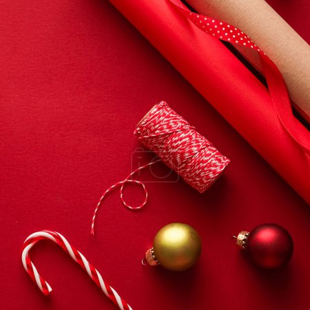 Foto de Preparación de Navidad, día de boxeo y días festivos, regalo, papel artesanal de Navidad y cintas para cajas de regalos sobre fondo rojo como herramientas de envoltura y decoraciones, regalos de bricolaje como diseño de laicos planos de vacaciones - Imagen libre de derechos