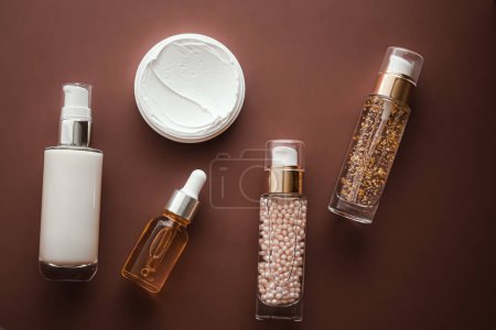 Téléchargez les photos : Skincare cosmetics and anti-aging beauty products, luxury skin care bottles, oil, serum and face cream on brown background. - en image libre de droit