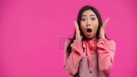 Foto de Impactado y joven mujer asiática con la boca abierta gesto aislado en rosa - Imagen libre de derechos