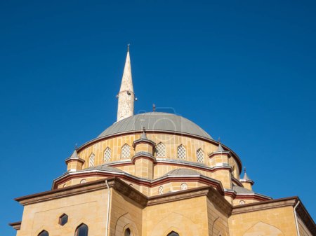 Téléchargez les photos : Alanya, Turquie - 4 janvier 2023. Fragment du bâtiment de la mosquée Fatih Sultan Mehmet aux rayons du soleil du matin, sur fond de ciel bleu clair - en image libre de droit