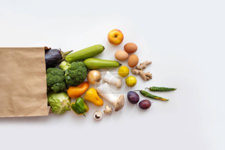 Healthy food delivery background. Healthy vegan vegetarian food in paper bag vegetables and fruits on white, copy space, banner. Supermarket shopping and pure vegan food concept.