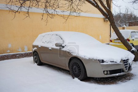 Foto de Coche bajo la nieve. Coche aparcado cubierto de nieve. - Imagen libre de derechos