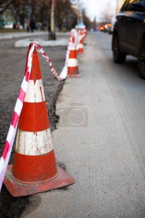 Photo for Under construction board sign on the closed road with arrow sign and traffic cone. Caution symbol under construction, work in progress sign. - Royalty Free Image
