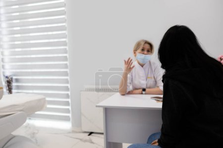Women's health and beauty consultation with a cosmetologist. Doctor cosmetologist. Patient at reception in beauty salon. Health discussion, examination and appointment skin care and treatment