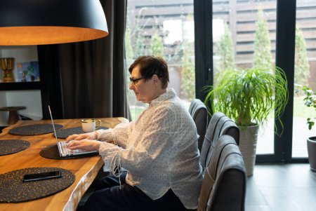 Senior mujer mayor madura viendo formación empresarial, webinar en línea en el ordenador portátil de trabajo a distancia o aprendizaje a distancia social desde el hogar. 60s empresaria videollamada en chat virtual